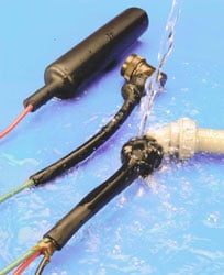 Two laser pointers with brass and black components on a blue surface.