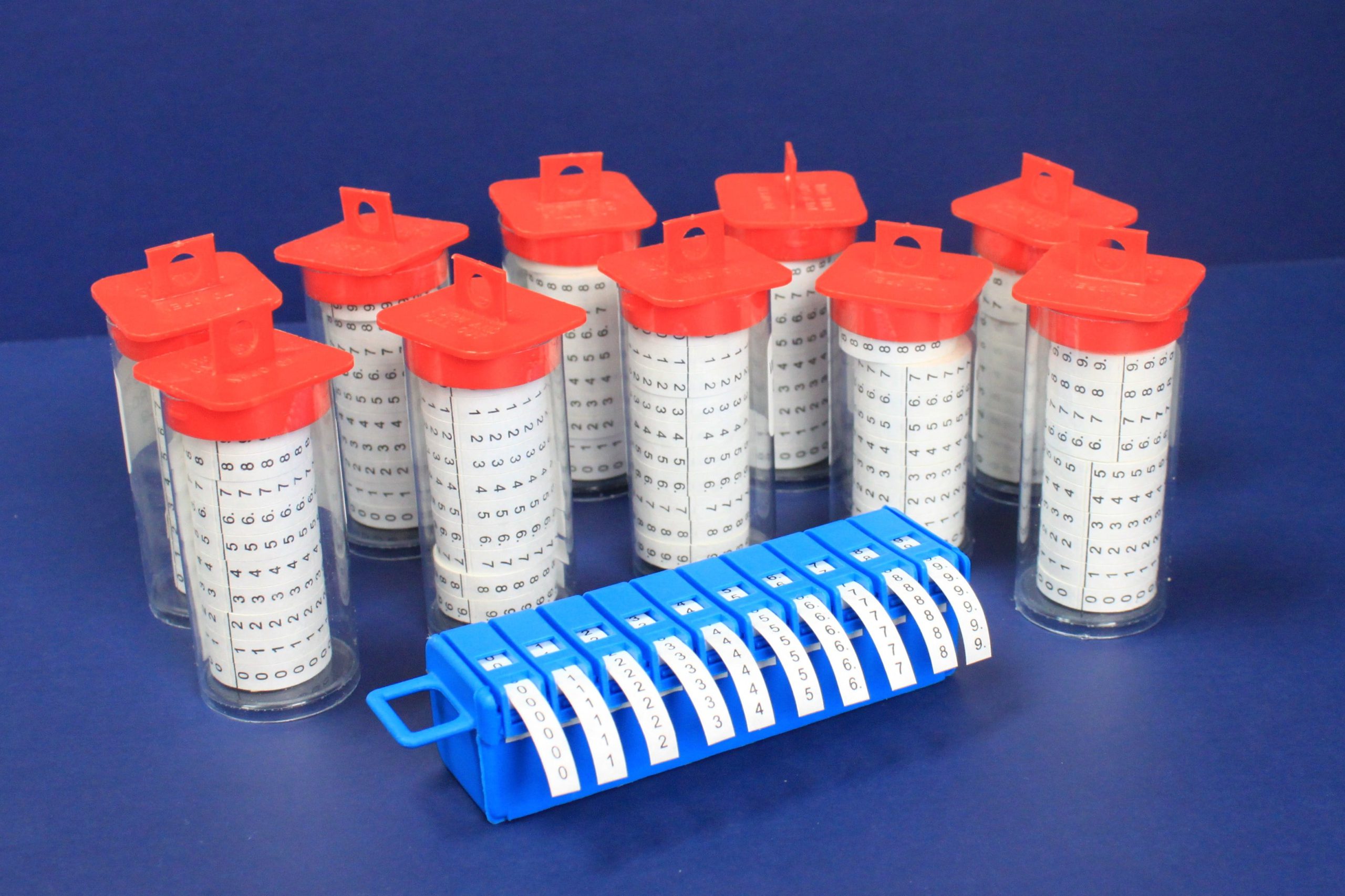 Ten clear cylindrical containers with red lids and numbered labels arranged behind a blue label.