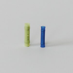 Two cylindrical battery connectors, one yellow-green and one blue, on a white surface.