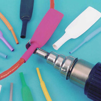 Markers and a paint brush arranged on a turquoise surface.