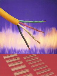 A hand holds scissors above an audio waveform displayed on a computer screen.