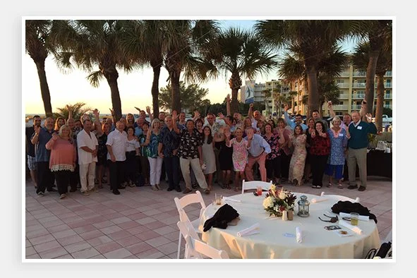 Nelco employees gathered outside of a hotel for a group photo