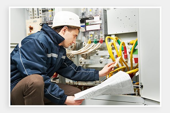 Technician with schematic at breaker box