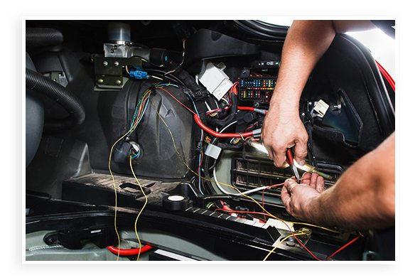 Technician with wires under car hood