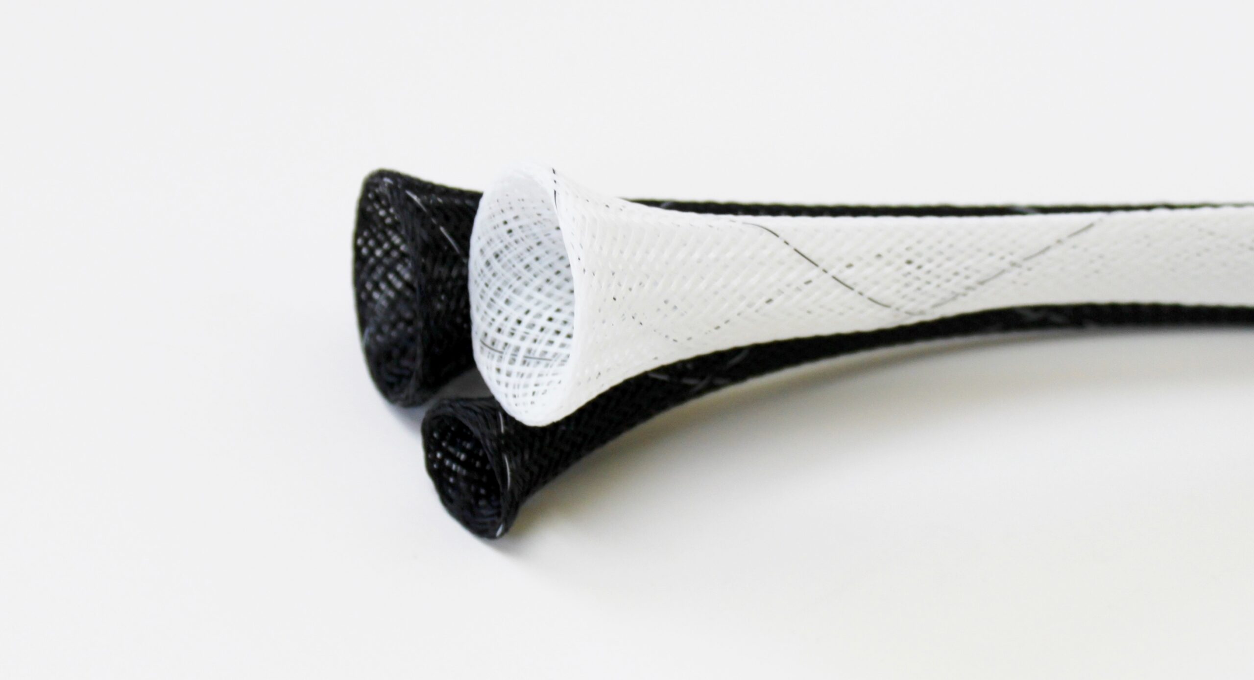 Lacrosse stick head with black and white mesh netting on white background.