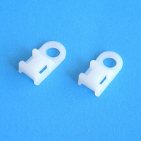 Two white plastic cable clips on a blue background.