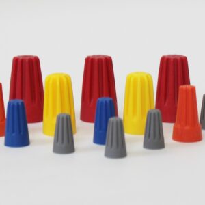 Assorted wire connectors in red, yellow, blue, and gray arranged on a white surface.