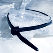 A person in dark clothing lies on snow in a star position.