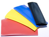 Folded fabric swatches in yellow, blue, red, and black colors stacked together.