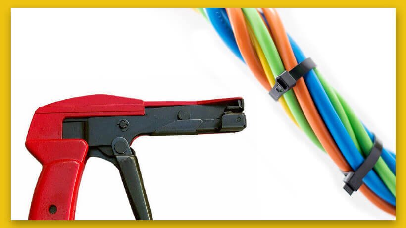 Cable tie gun with red handle next to bundled colored wires secured with black ties.