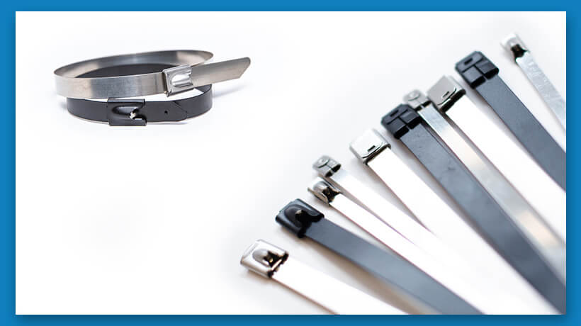 Two leather belts and six cable ties in various colors arranged on a white surface.