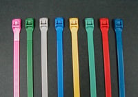 Assorted colored zippers arranged in parallel rows on a gray background.
