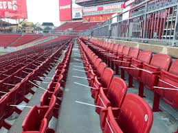 Empty red stadium seats arranged in rows at a sports venue.